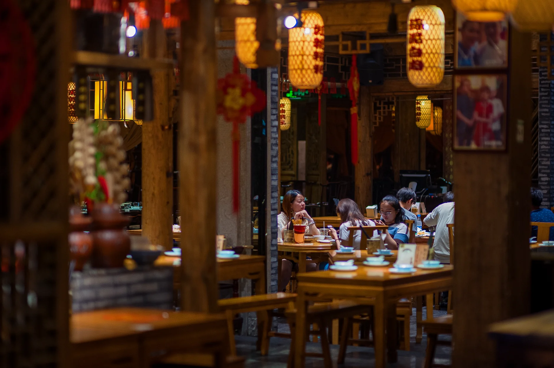 Atmospheric shot of people dining in a traditional Asian restaurant with warm lighting